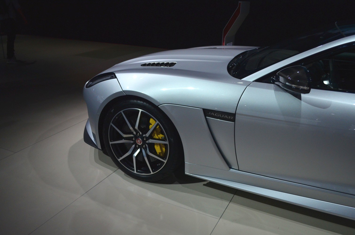 Front wheel with yellow brake calipers and side vent with Jaguar badge