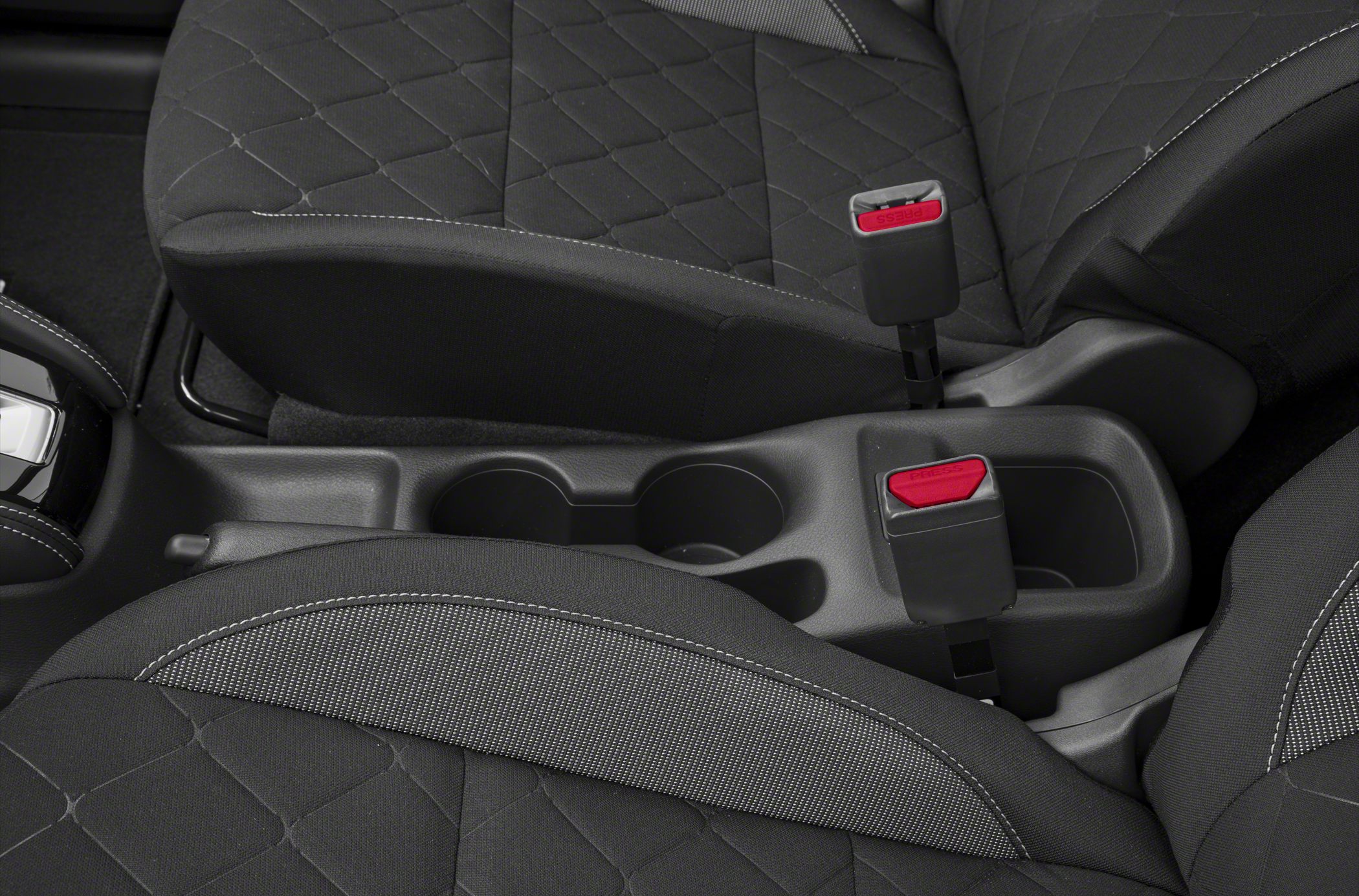Center console cup holders with adjacent seat belt buckles and fabric seats.