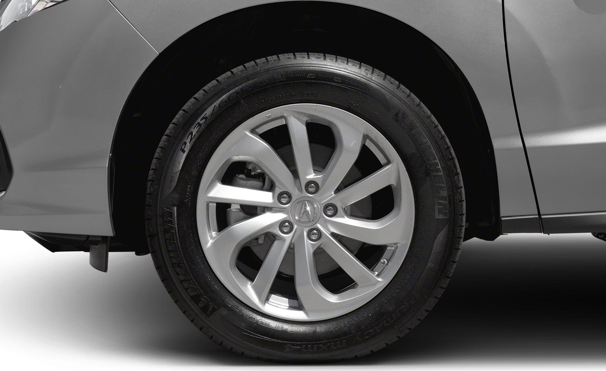 Close-up of alloy wheel and Michelin tire on vehicle front side.