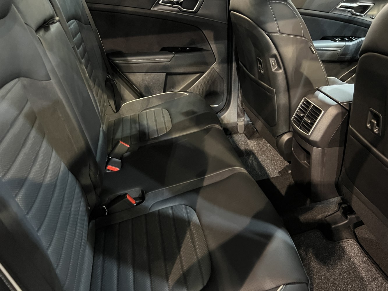 Rear passenger seat with leather upholstery and rear air vents in a modern SUV interior