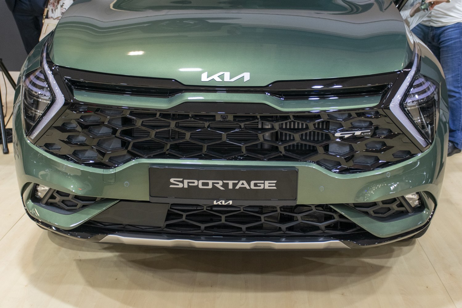 Close-up of front grille with distinctive LED headlights and honeycomb pattern