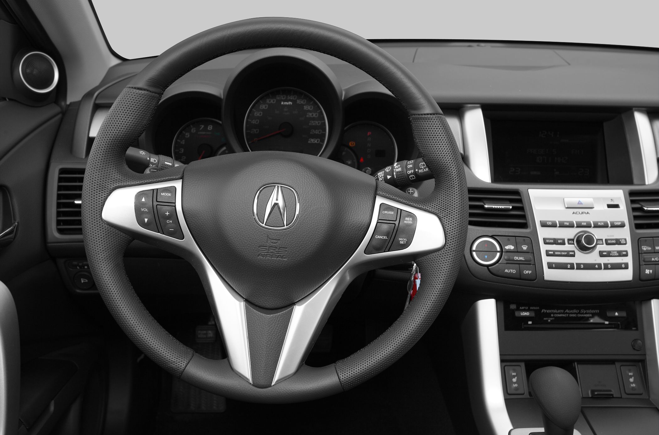 Steering wheel with control buttons and dashboard with instrument cluster and audio system