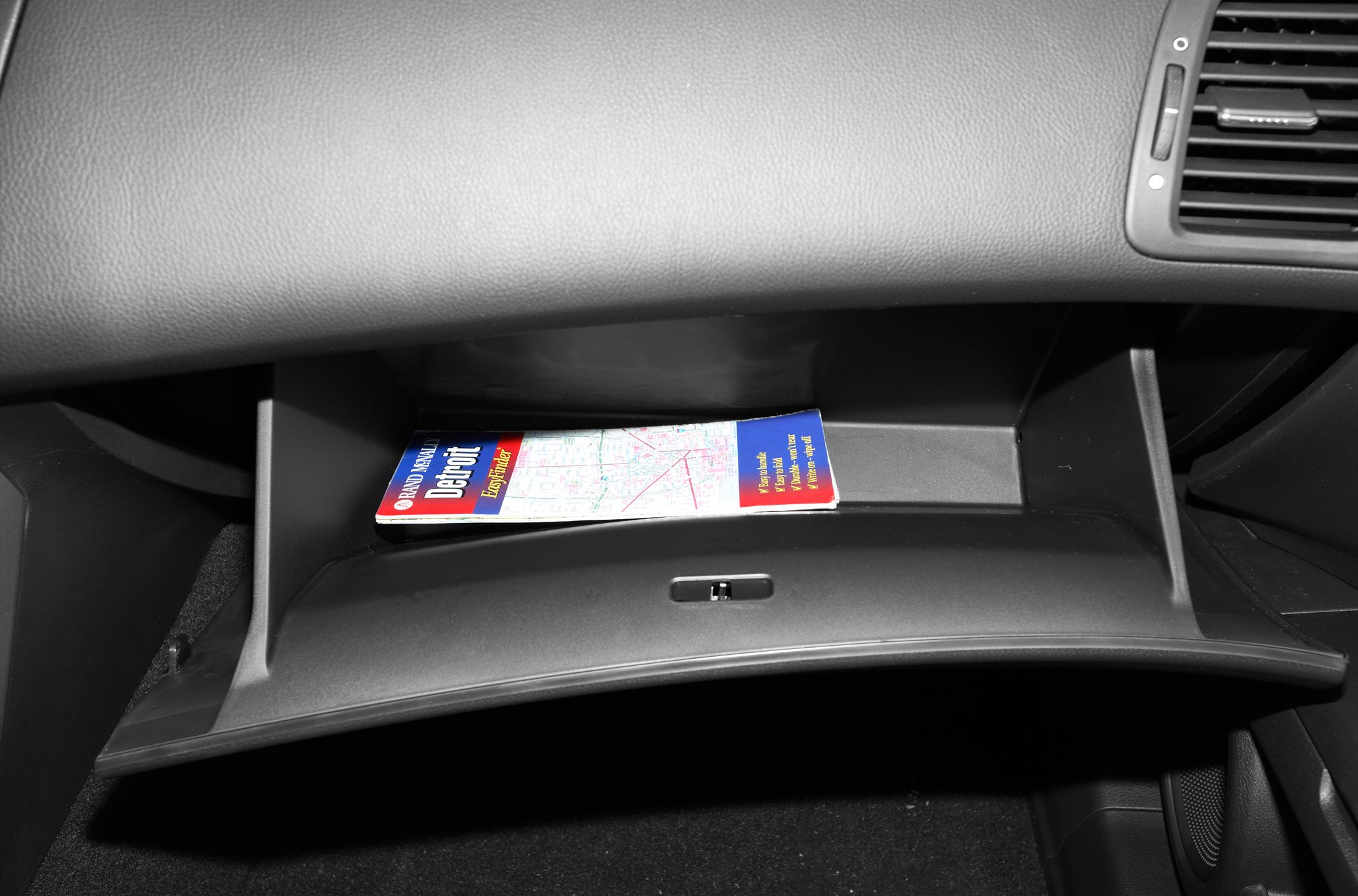 Open glovebox with manual inside in car interior