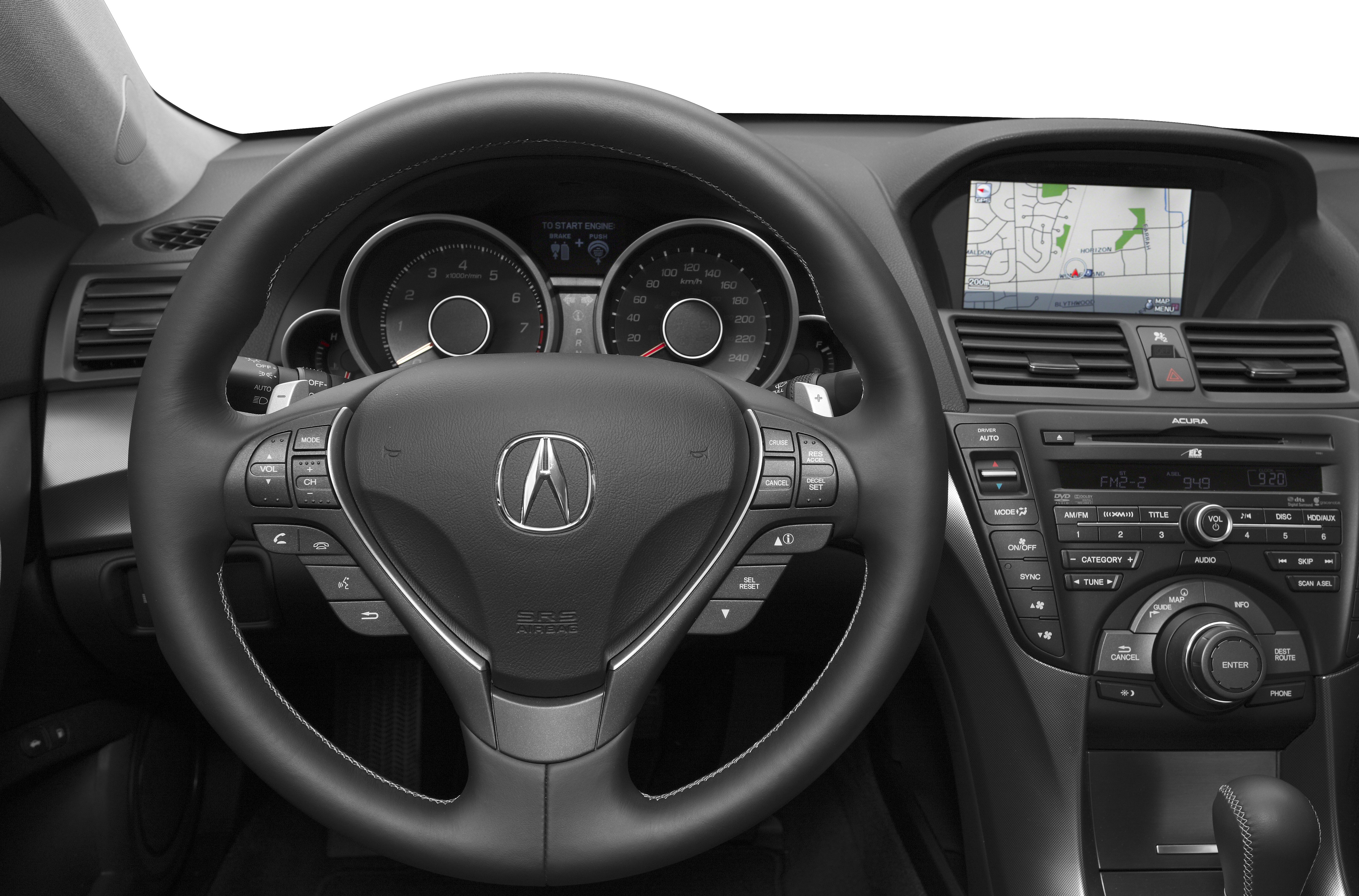 Steering wheel with controls and dashboard with navigation screen.