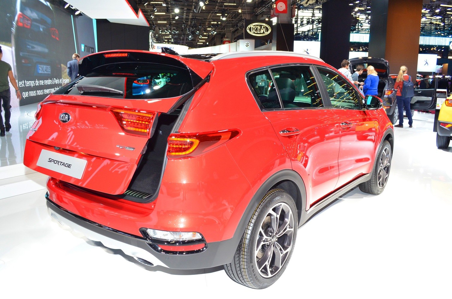 Red SUV rear with open tailgate and alloy wheels.