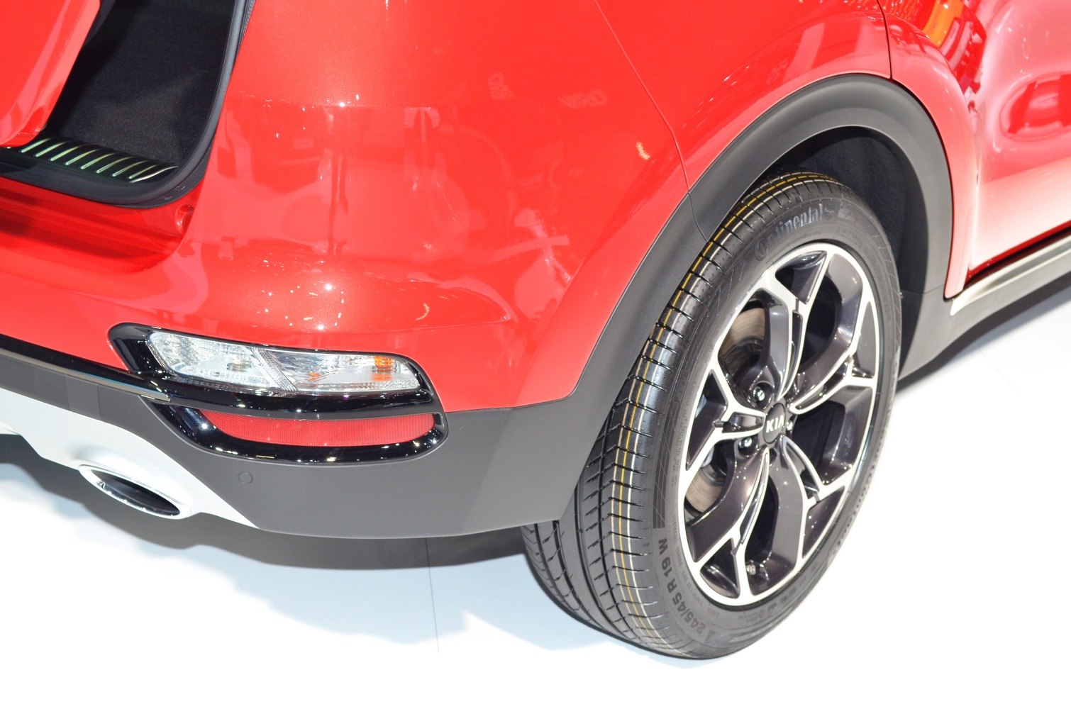 Close-up of rear alloy wheel and tail light on red vehicle