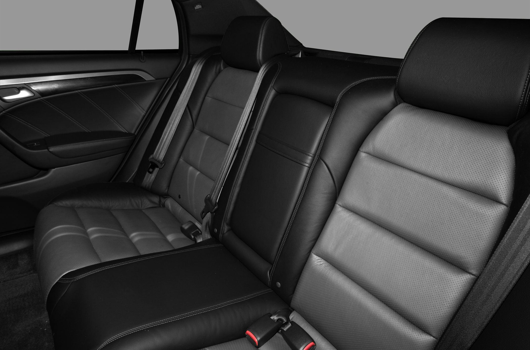 Rear black leather seats with detailed stitching and seat belts
