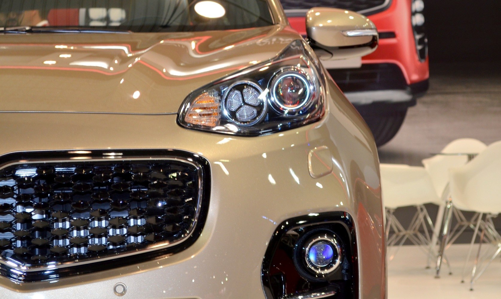 Close-up of SUV front headlight, grille, and fog light
