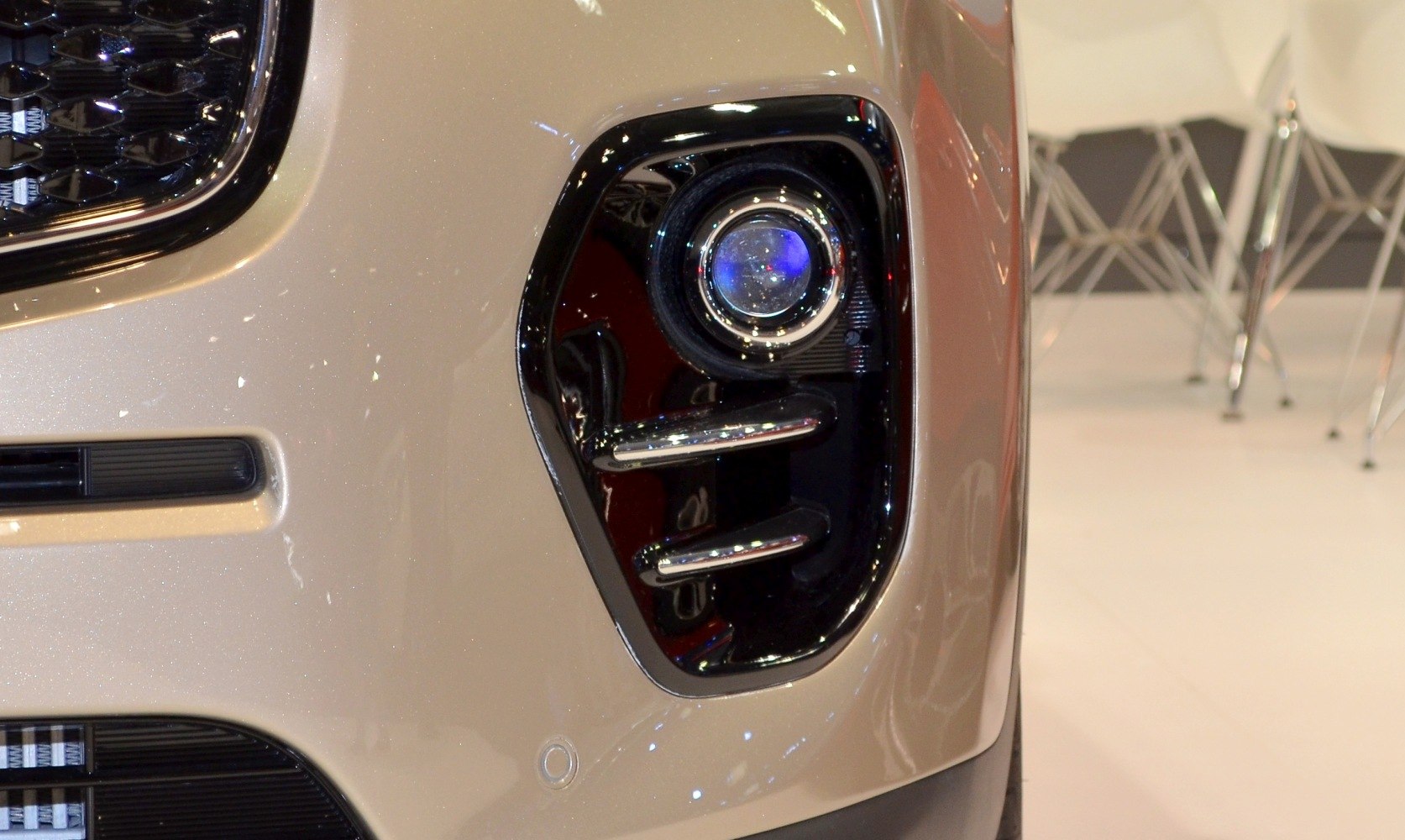 Close-up of front fog light with dual chrome bars and adjacent grill section