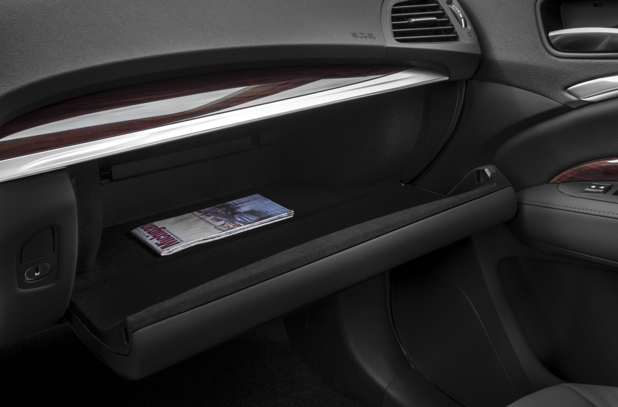 Open glove compartment with wood and leather trim inside car