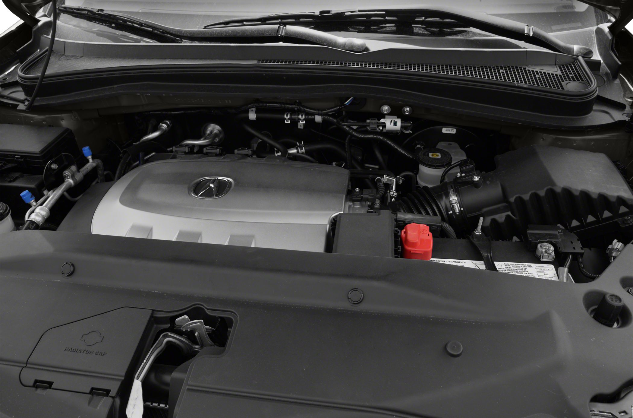 Engine bay view with engine cover, air intake, battery, and radiator cap