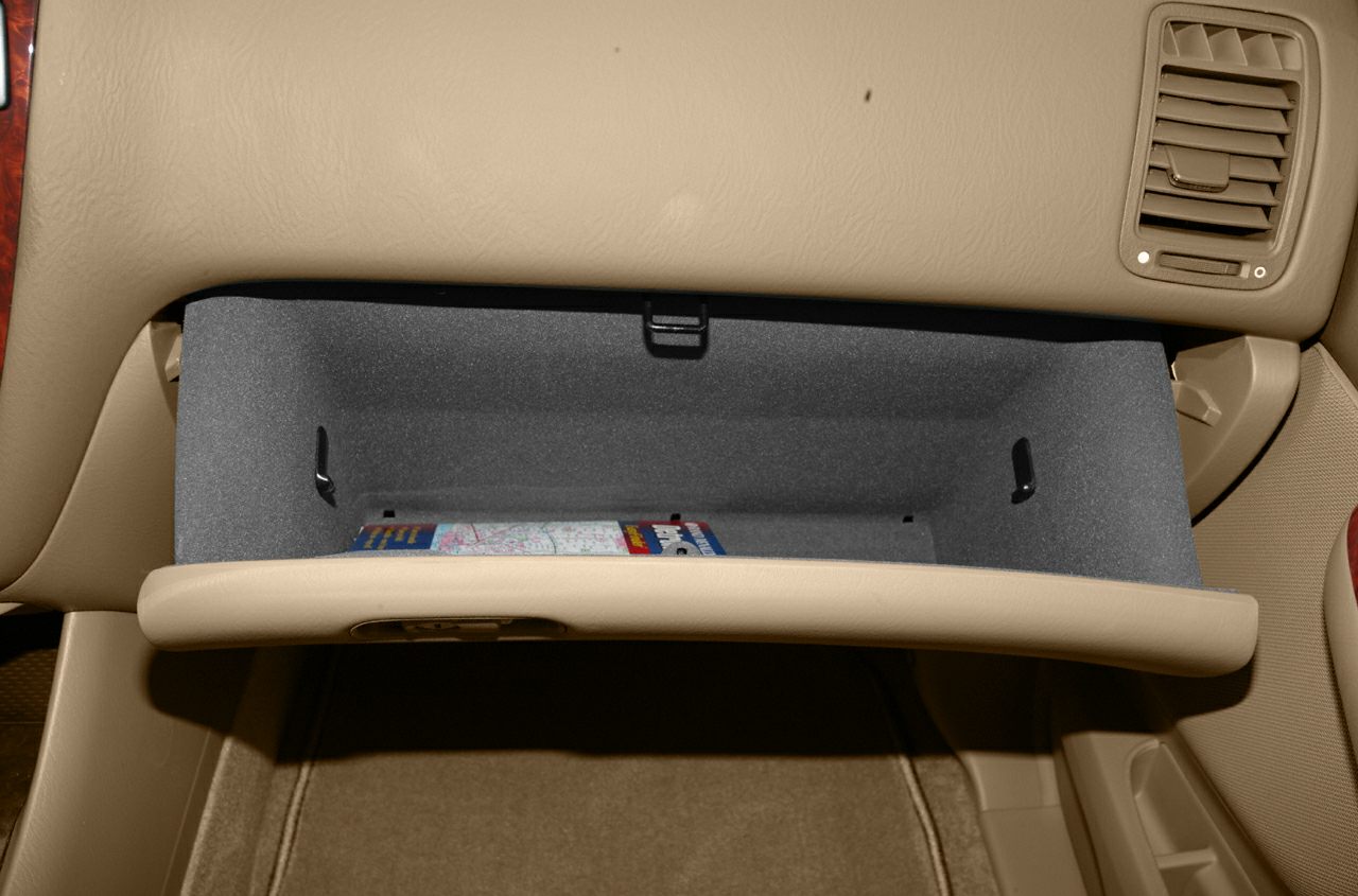 Open glove compartment with beige interior and adjacent air vent.