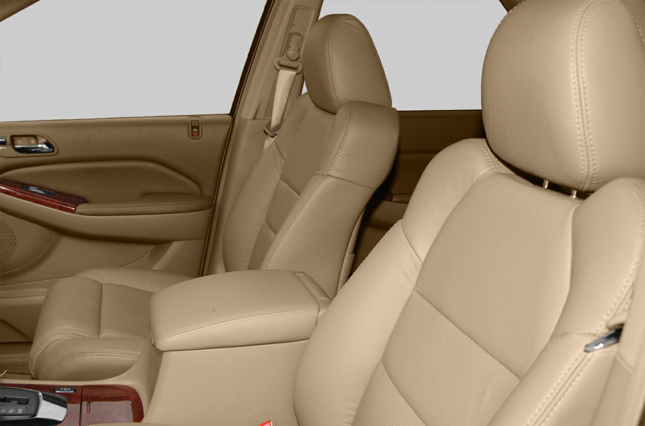 Beige leather front seats with armrest and wood trim on door