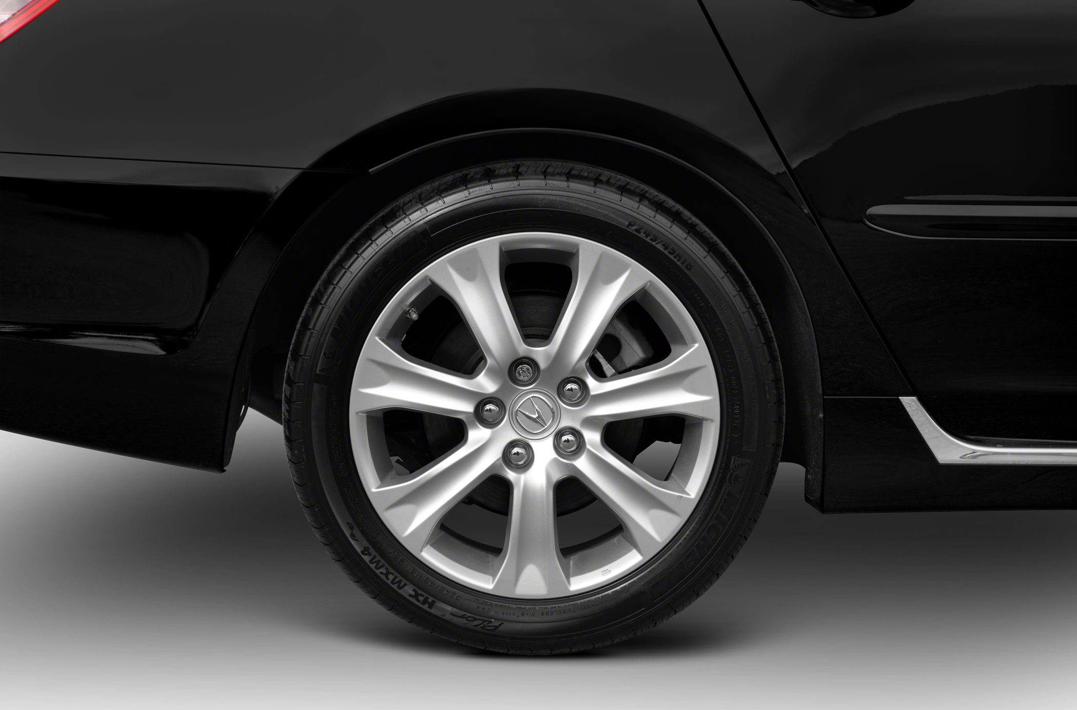 Silver 7-spoke alloy wheel with Michelin tire on black vehicle