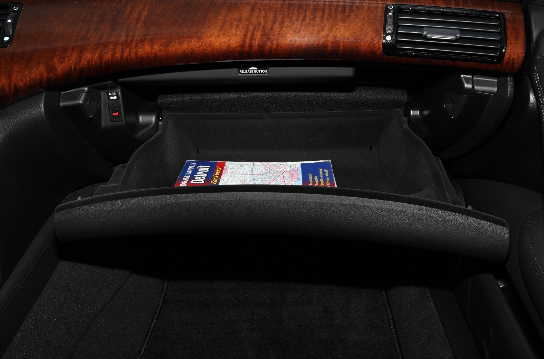 Open glove box with wood dashboard trim and side air vent