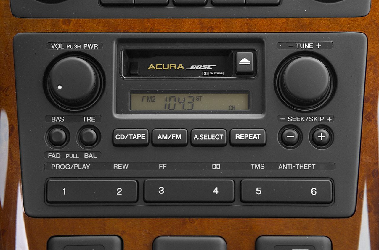 Vintage car radio with Bose cassette player and control knobs on wood trim