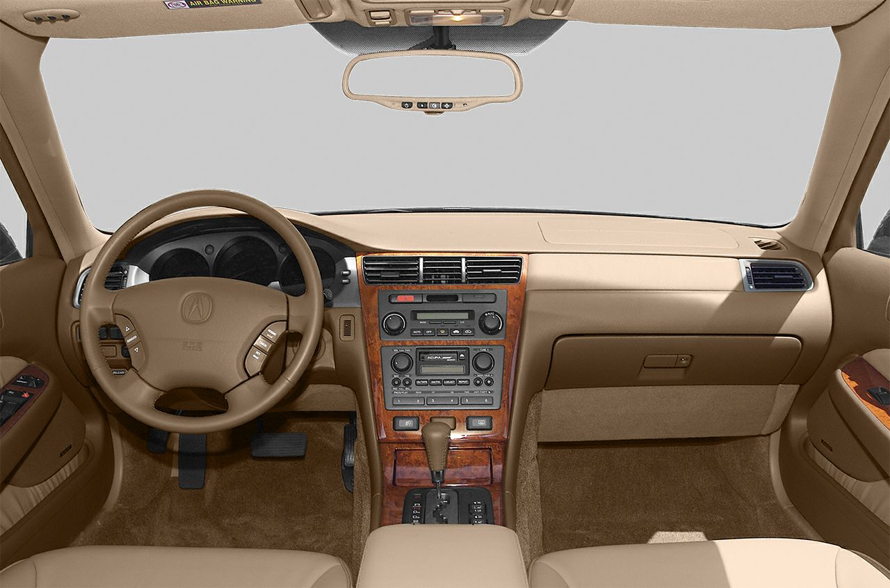 Beige interior with wood trim, steering wheel, analog controls.