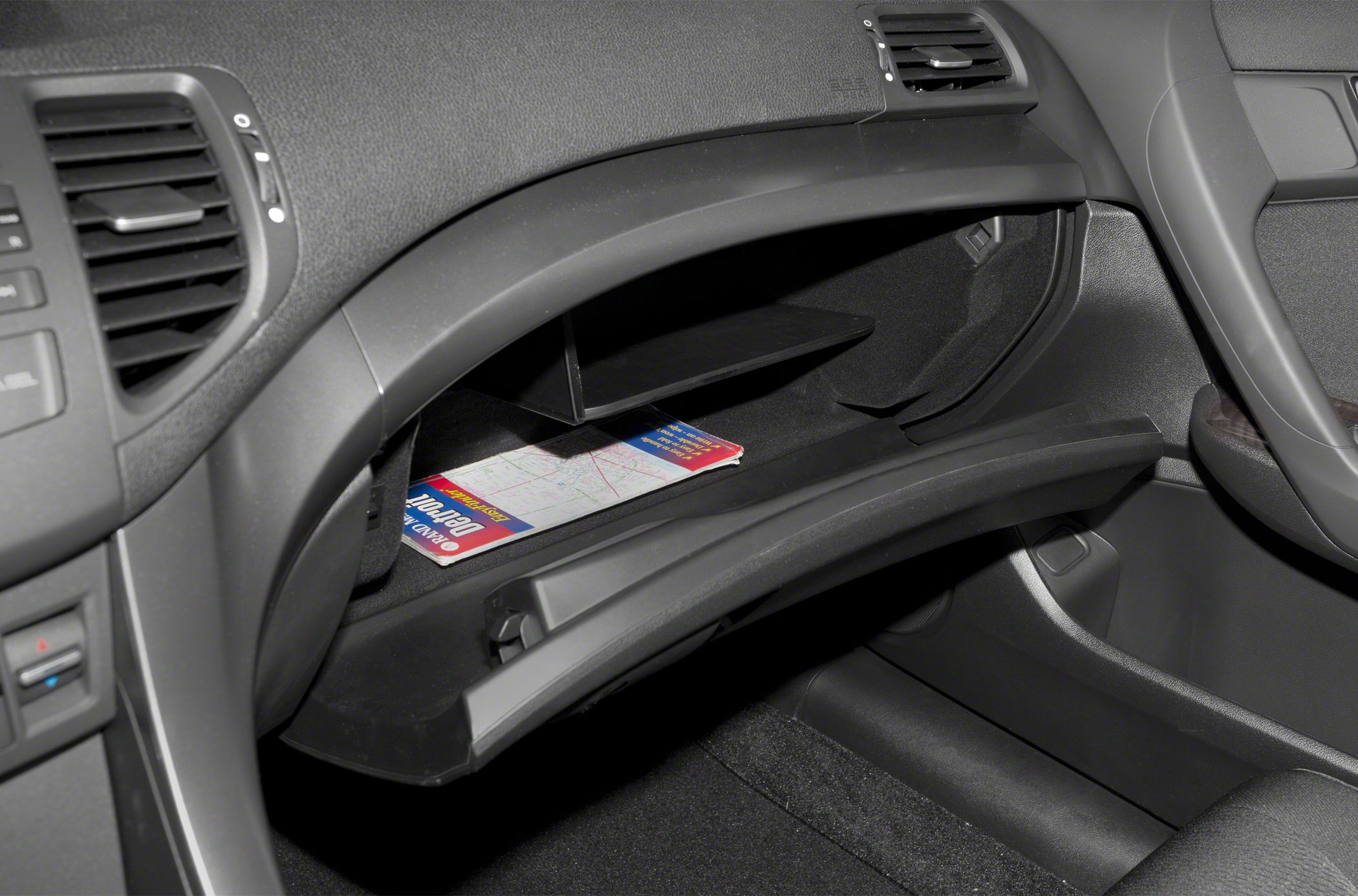 Open glove compartment with shelf and stored booklet