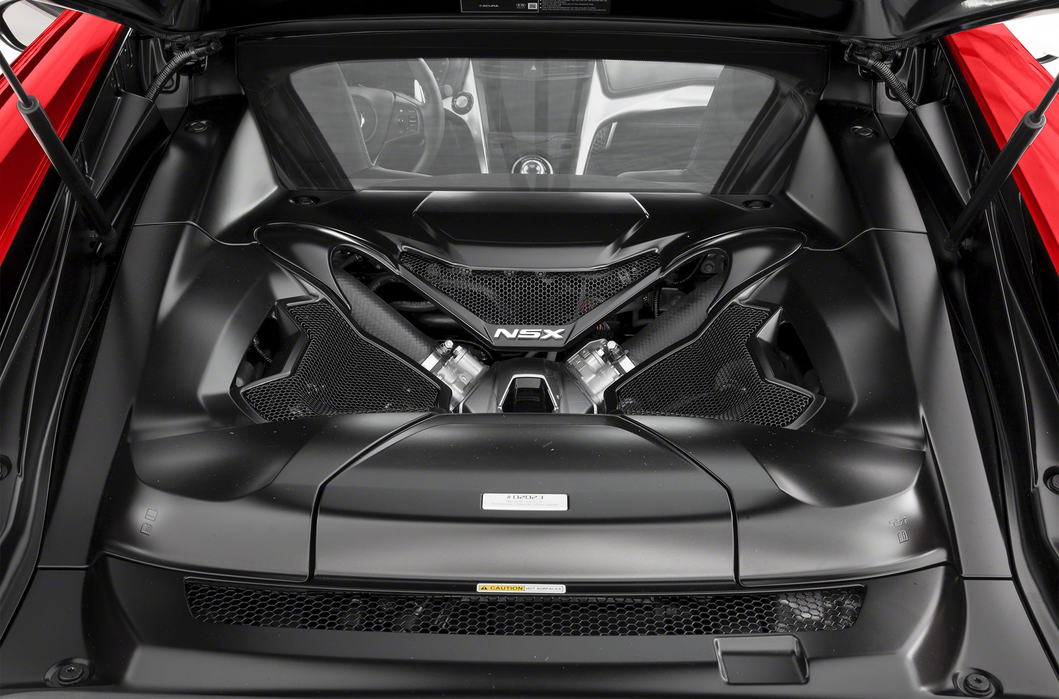 Close-up of Acura NSX II mid-engine compartment with black components and mesh vent details