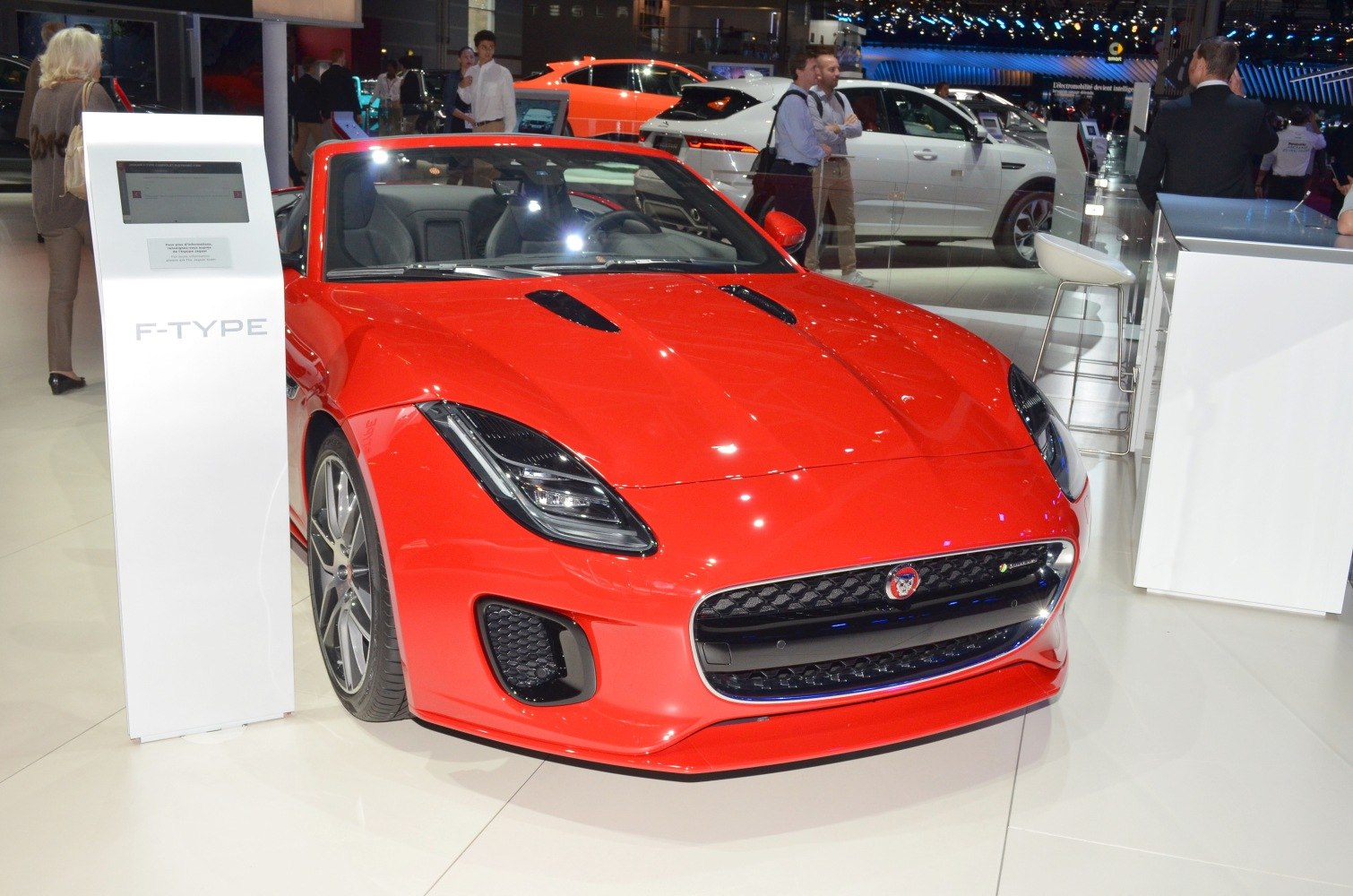 Red convertible sports car front with sleek headlights and aggressive grille