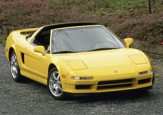 Yellow targa-top sports coupe with pop-up headlights and mid-engine layout
