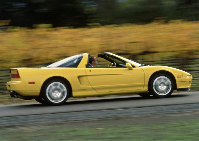 Side view of yellow sports convertible with targa roof in motion