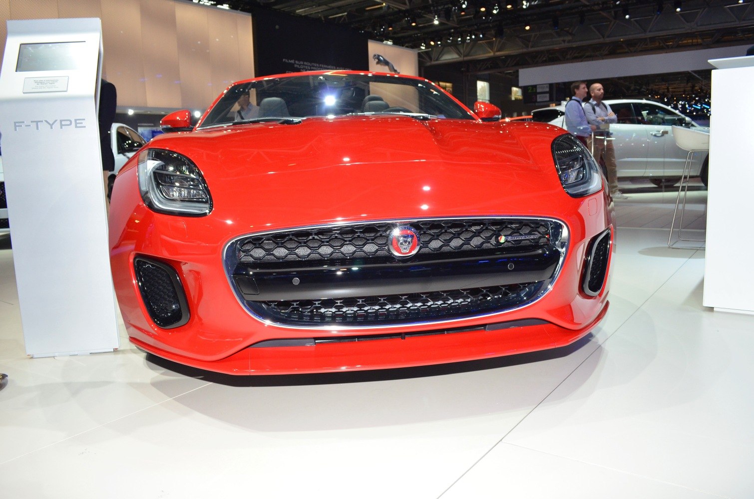 Front view of a red sports car with honeycomb grille and sleek headlights