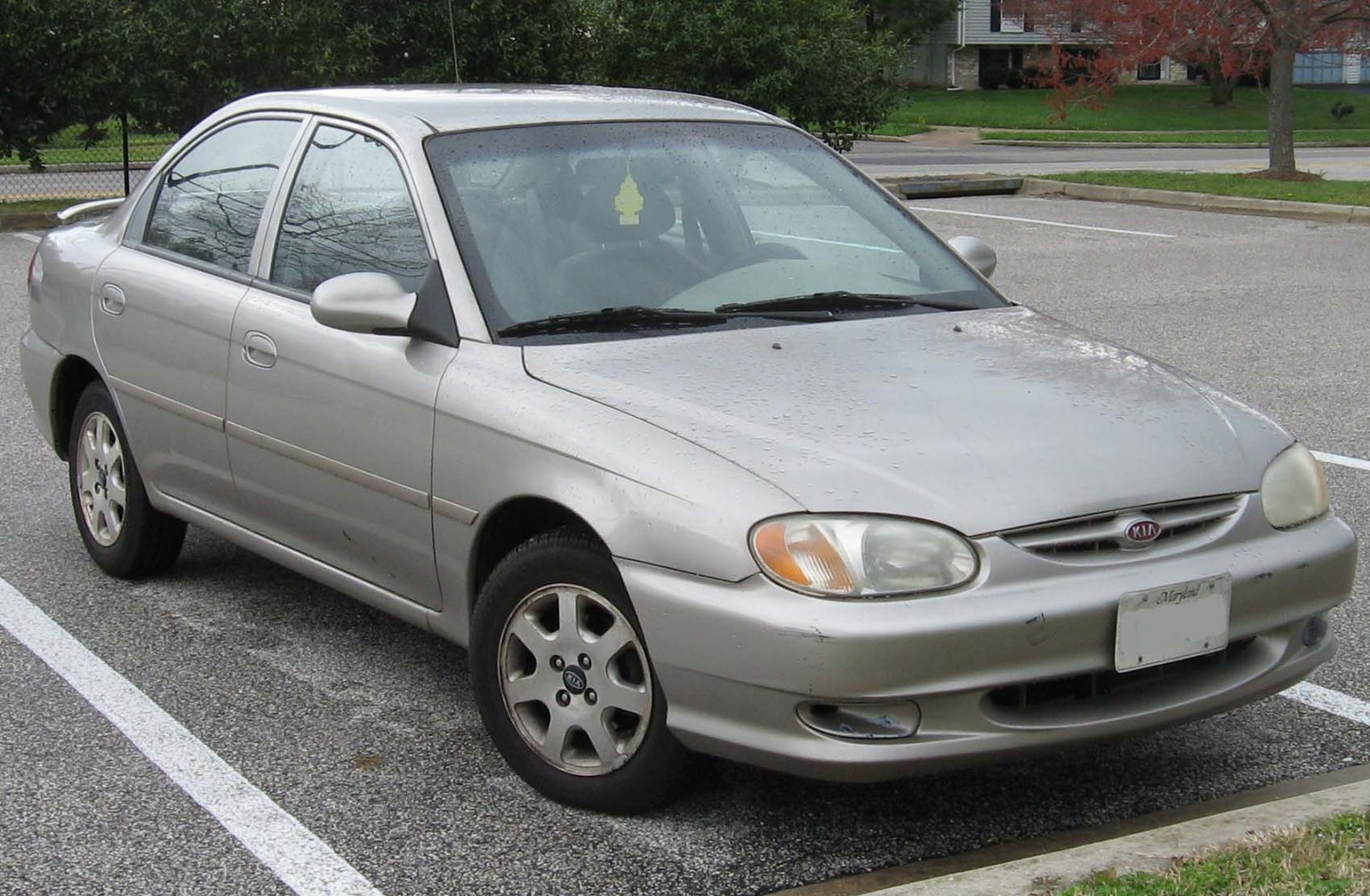 Front side view of silver compact sedan with rounded headlights and alloy wheels