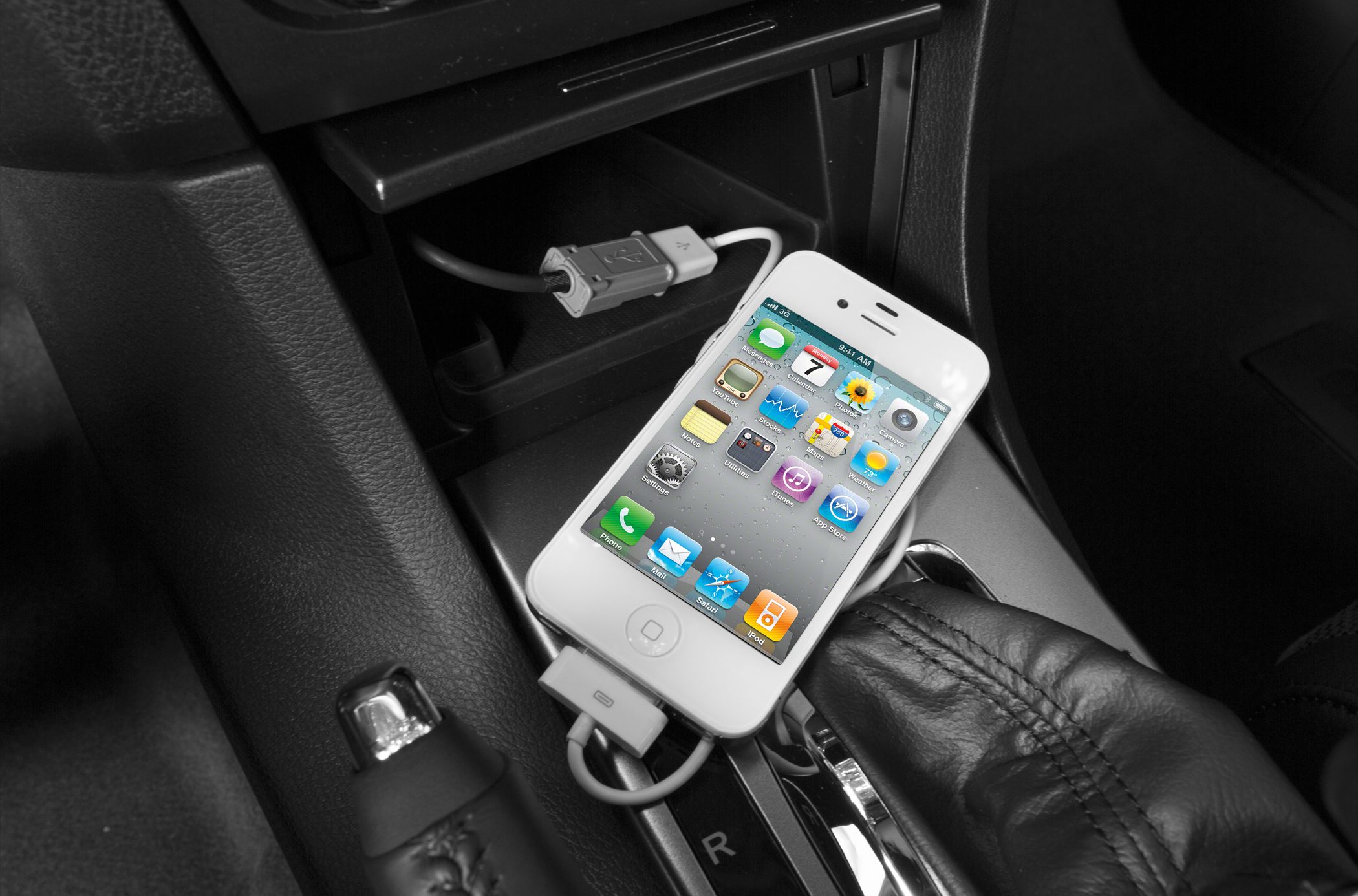 USB phone connection with iPhone on car console near leather gear shift