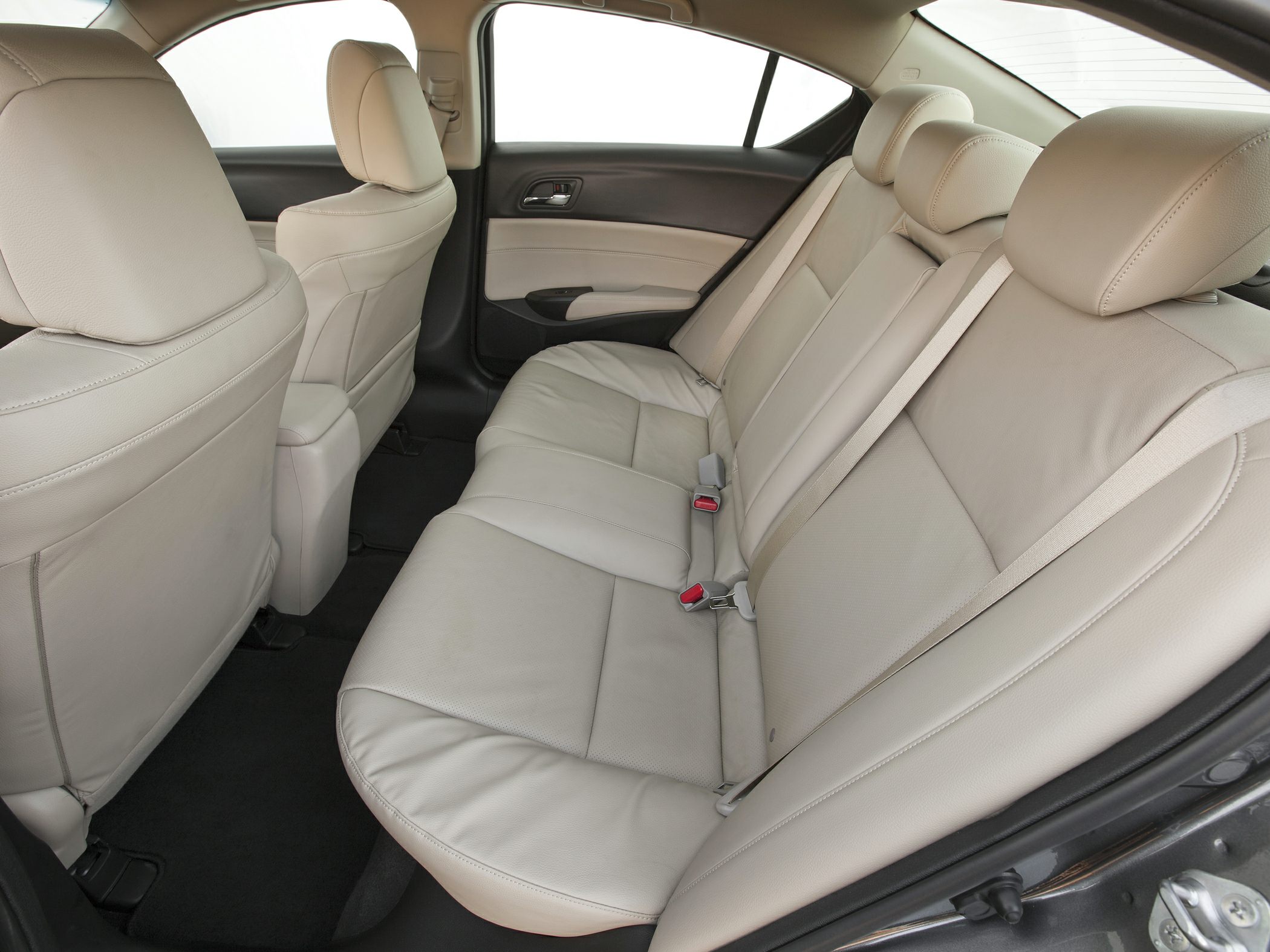 Beige leather rear seats with seat belts in spacious car interior
