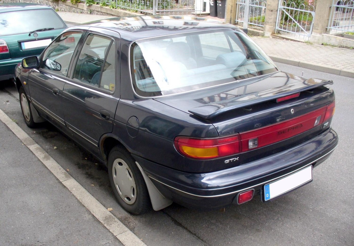 Rear view of sedan with spoiler and distinctive taillights.