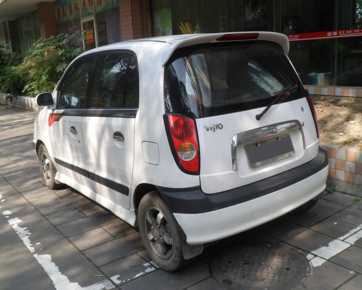 Rear and side view of compact hatchback with taillights and roof spoiler