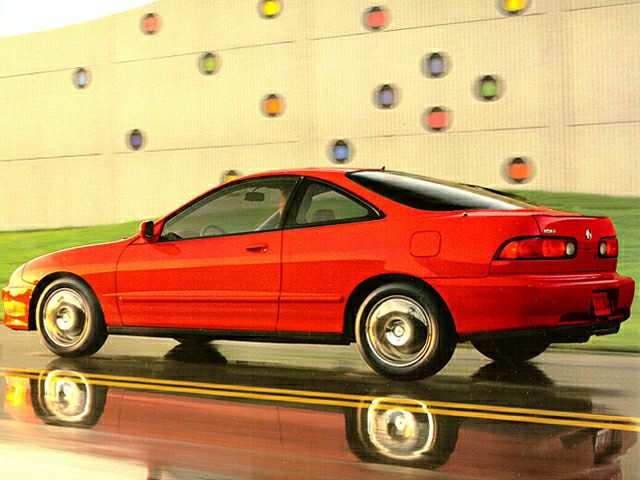 Red side view of a sleek two-door coupe on a reflective wet road