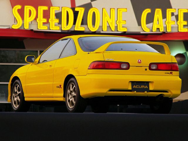 Rear view of yellow sporty coupe with distinctive taillights and spoiler