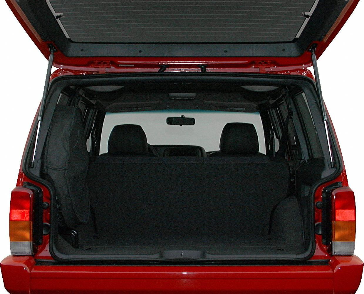 Open rear cargo space of red SUV with two front seats visible