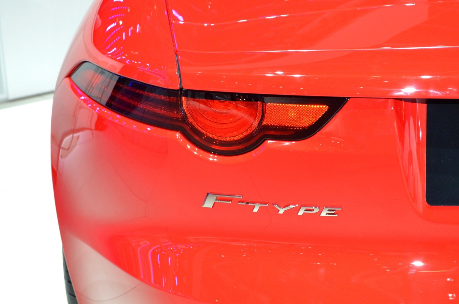 Rear LED tail light and F-type badge on red sports coupe