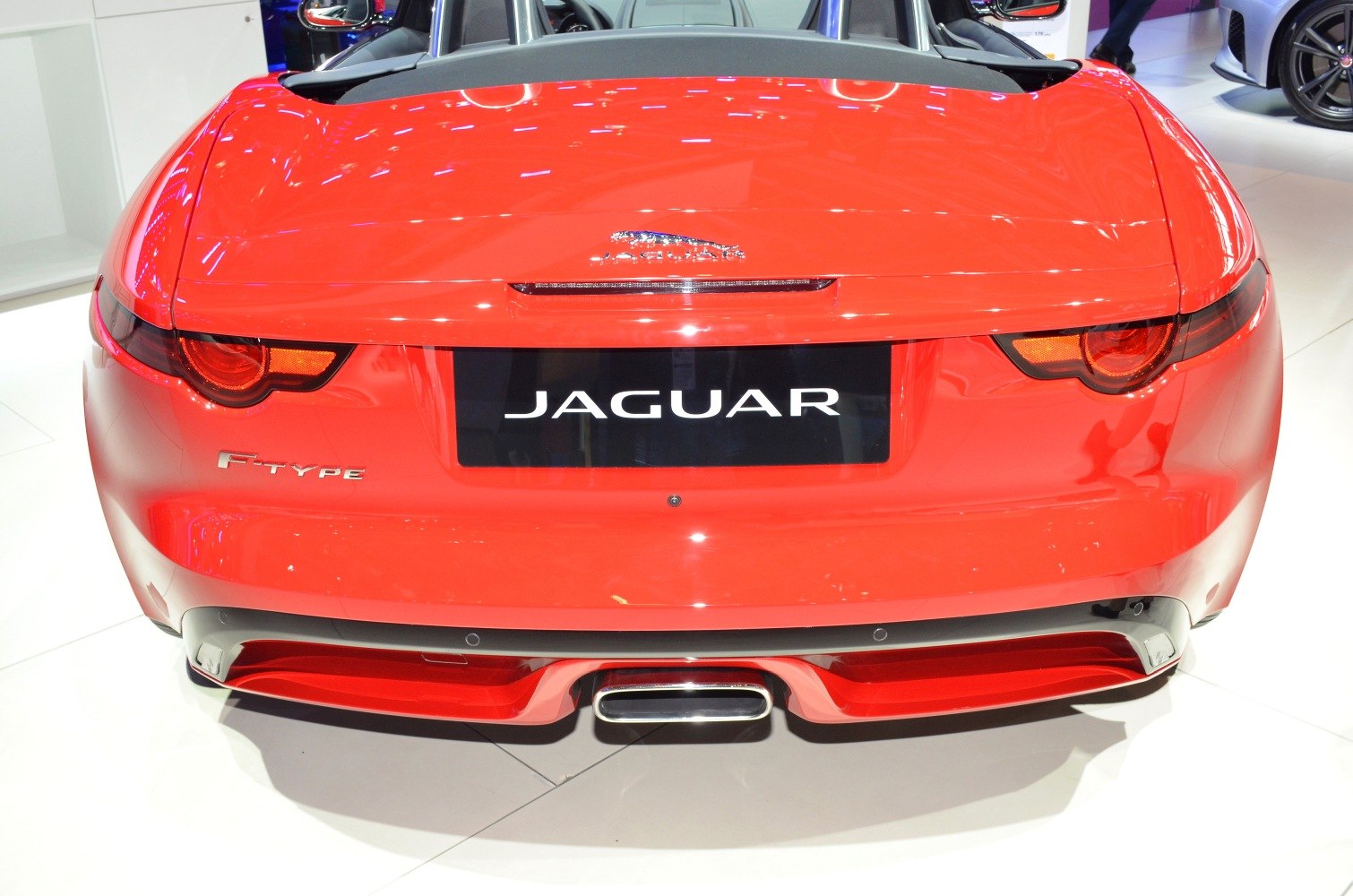 Rear view with tail lights and central exhaust of red convertible sports car