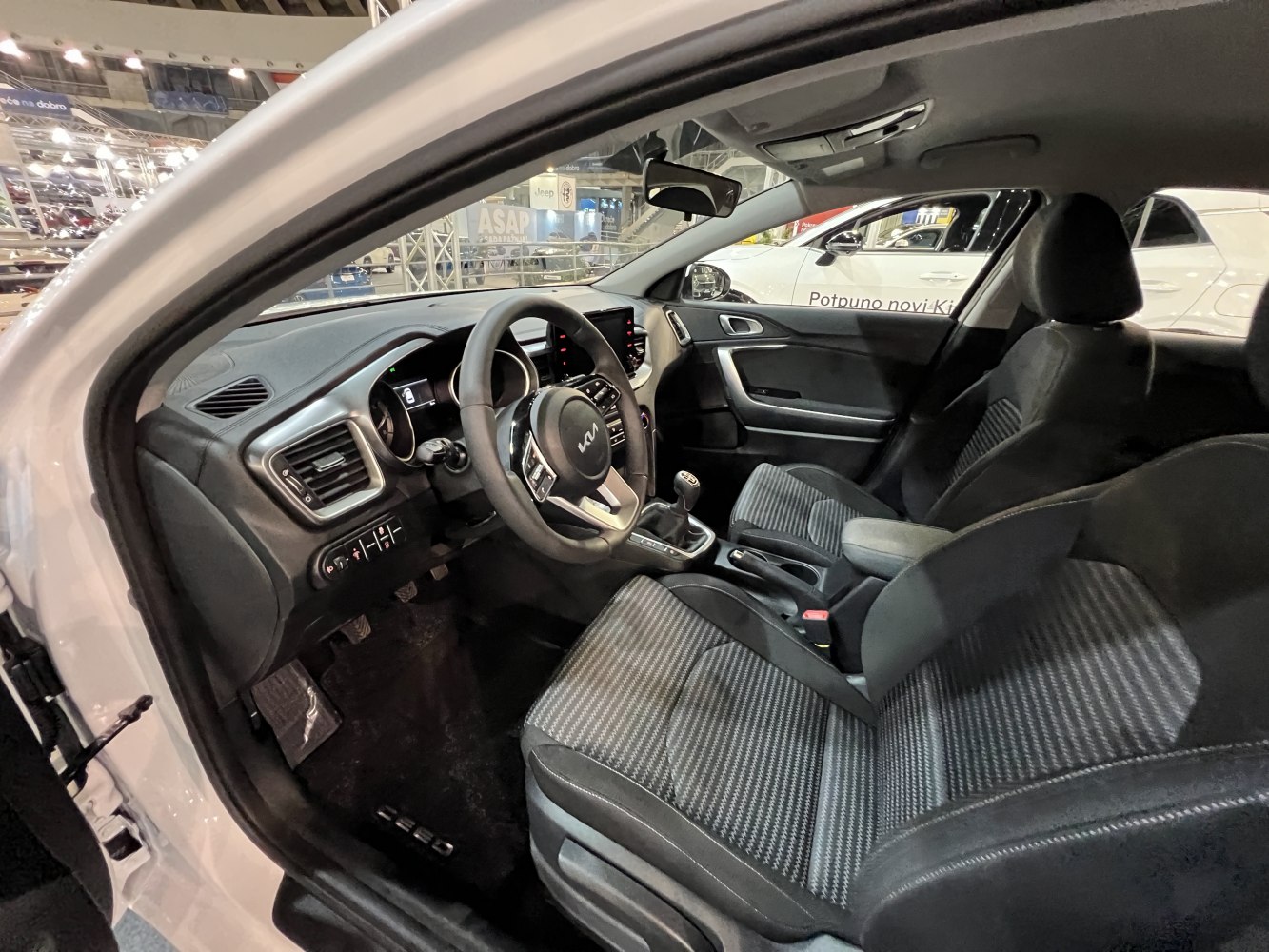 Interior with steering wheel, manual gear shift, and patterned seats