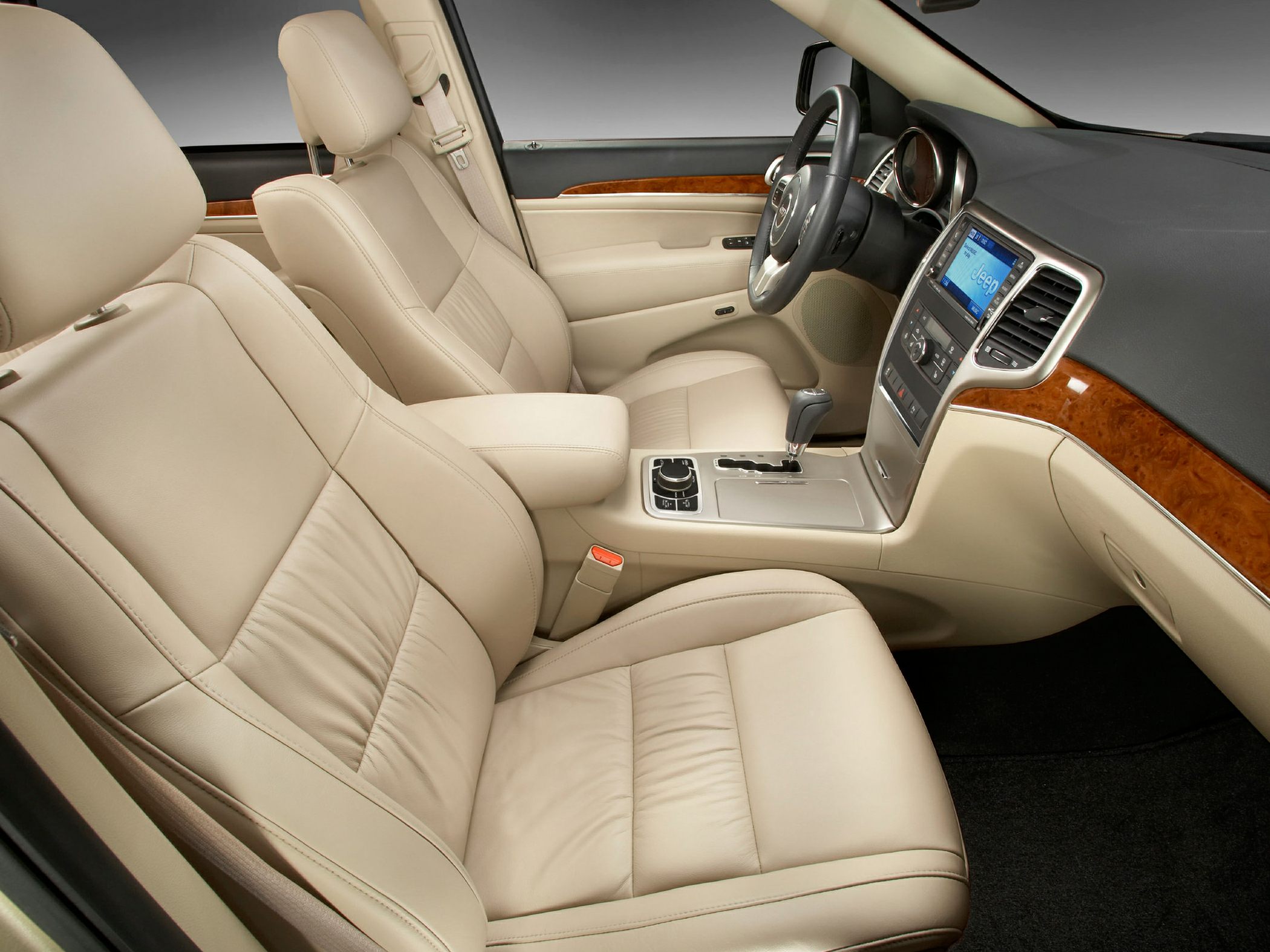 Beige leather seats with wood trim dashboard and center console.