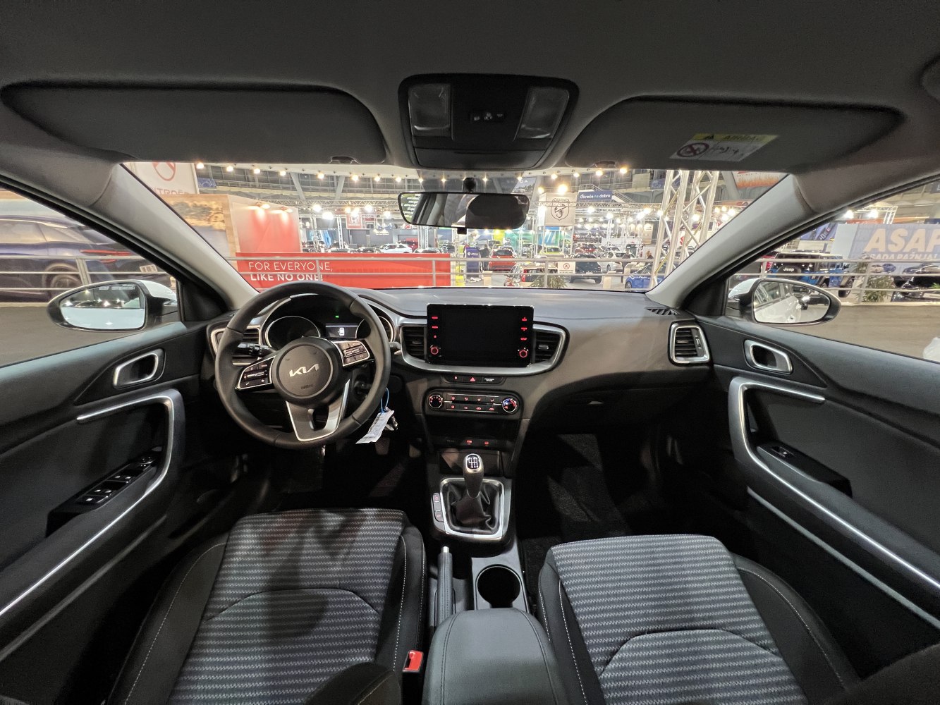 Modern car interior with dashboard, touchscreen, steering wheel, and manual gear shift