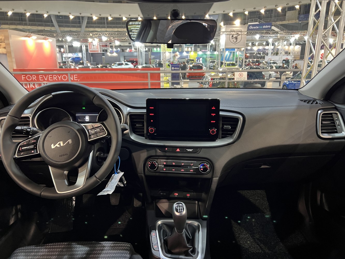 Interior view with steering wheel, dashboard, touchscreen, and manual gear shift