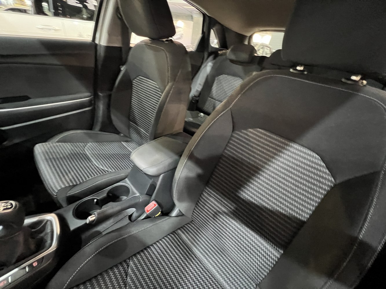 Fabric seats and center console with cup holders and handbrake