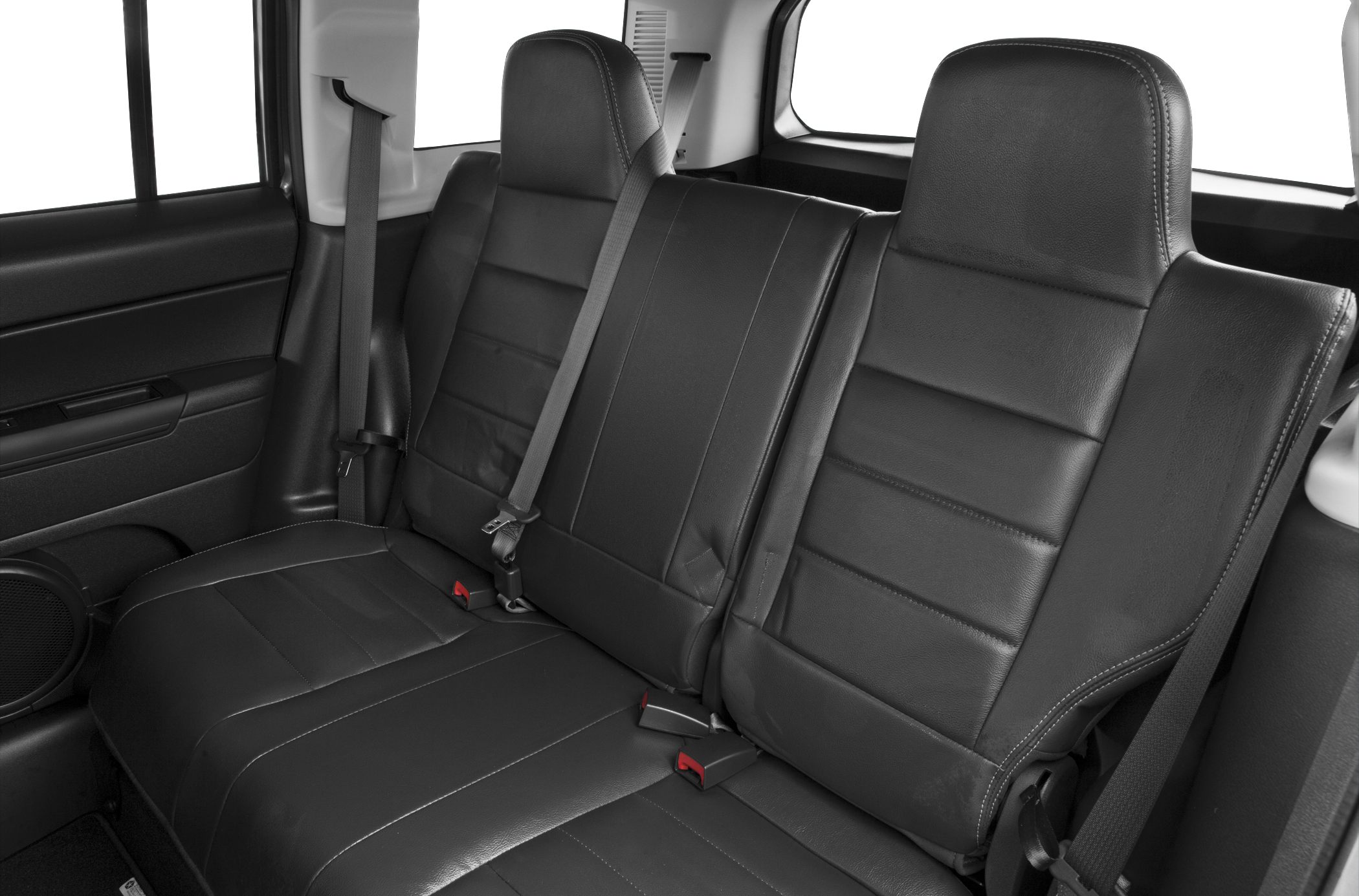 Rear leather seats with seat belts and headrests inside vehicle.
