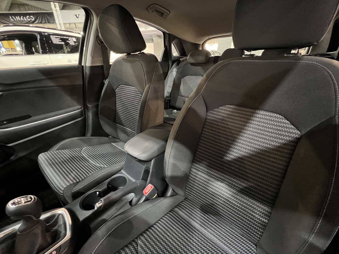 Fabric front seats and center console with manual gearshift and cup holders.