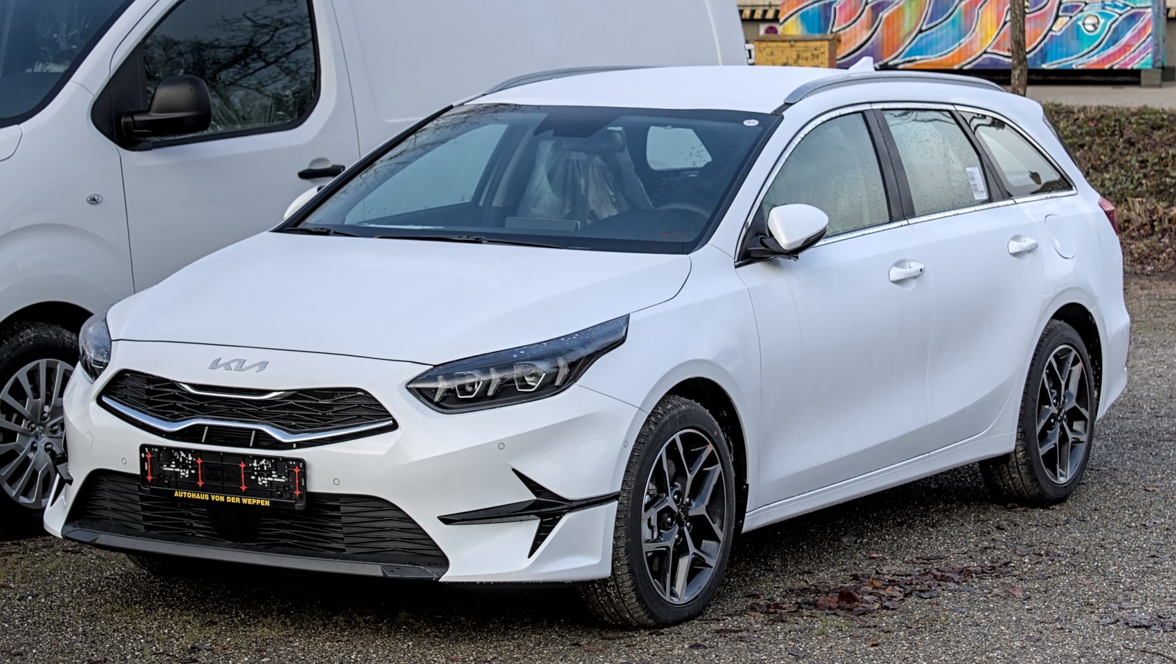 Front view of white station wagon with sleek LED headlights and modern grille.