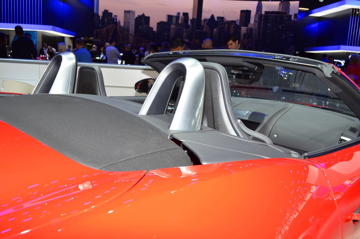 Convertible soft top and polished rear roll bars in a red sports car
