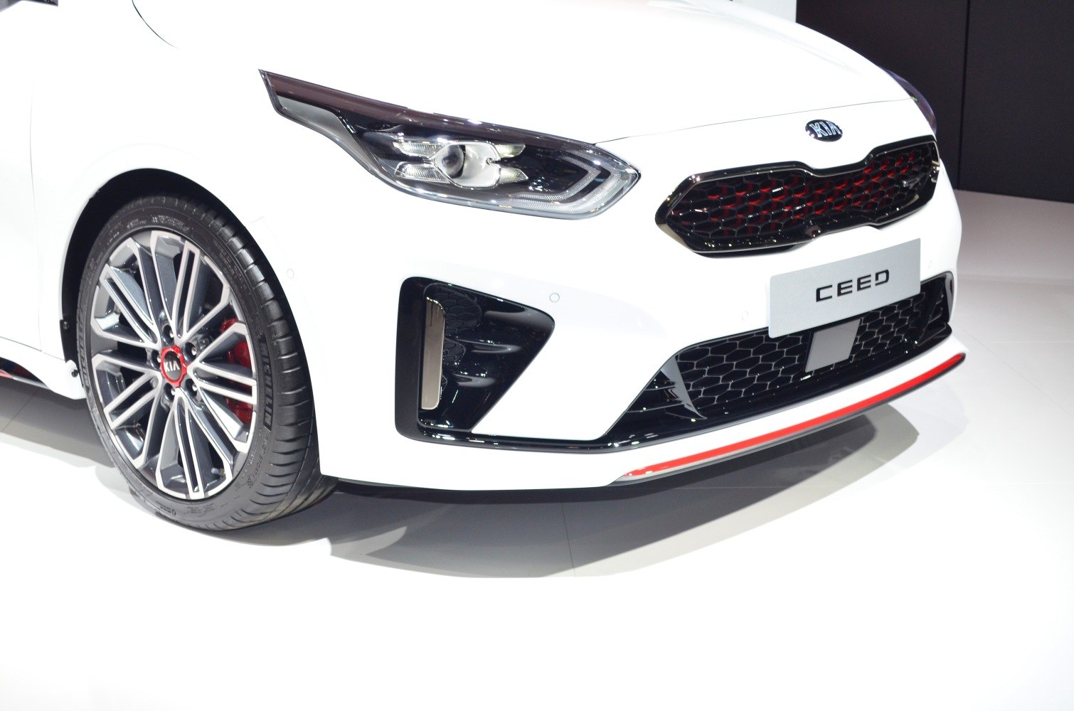Sporty front end with red-highlighted grille and detailed alloy wheel with tire