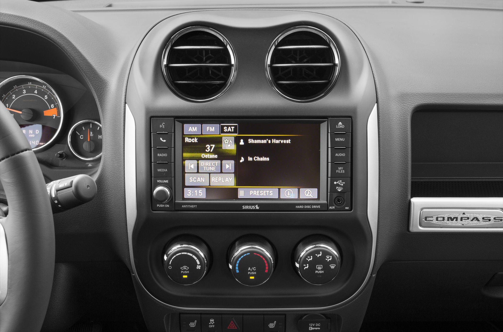 Jeep Compass dashboard with infotainment and climate control knobs.