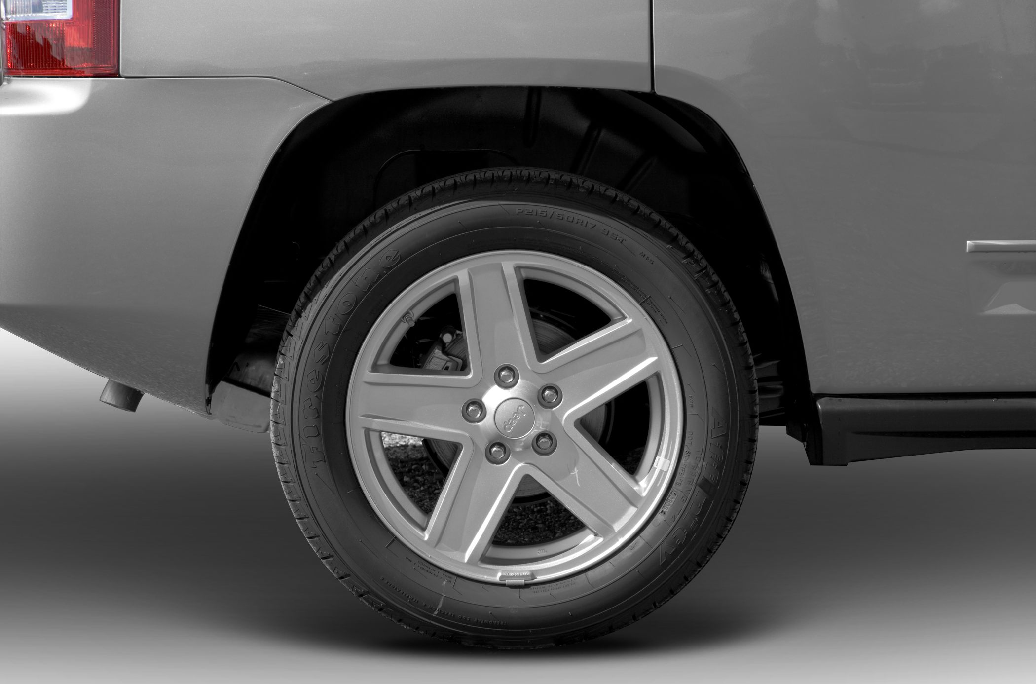 Close-up of alloy wheel with Firestone tire and rim design.