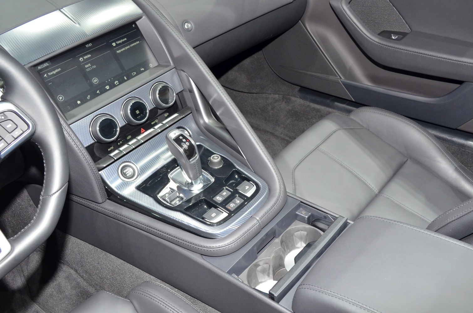 Center console with gear shift, climate controls, multimedia display, leather seats in luxury car interior
